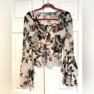 Cream floral blouse with bell sleeves.